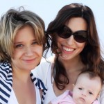 two beautiful girls with a baby on the beach two beautiful girls with a baby on the beach